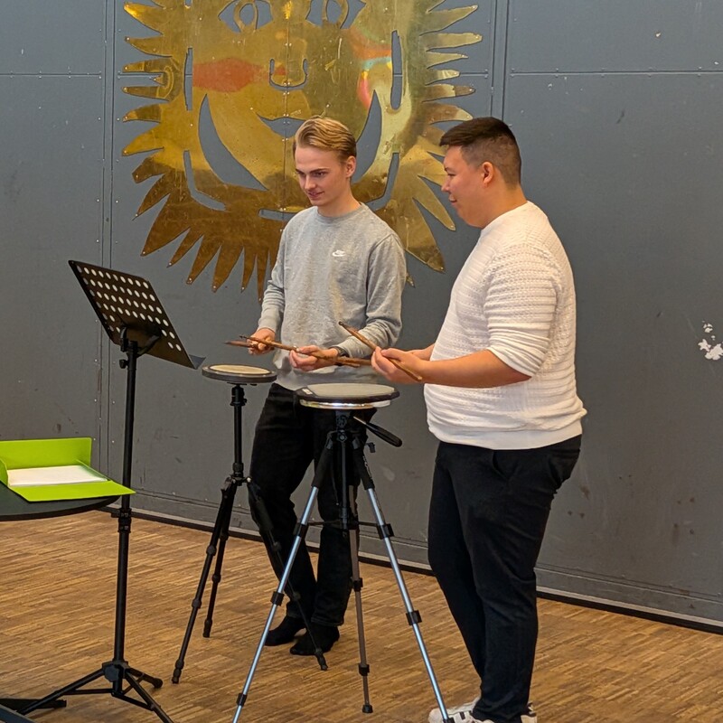 To unge mænd øver på deres tromme øveplader